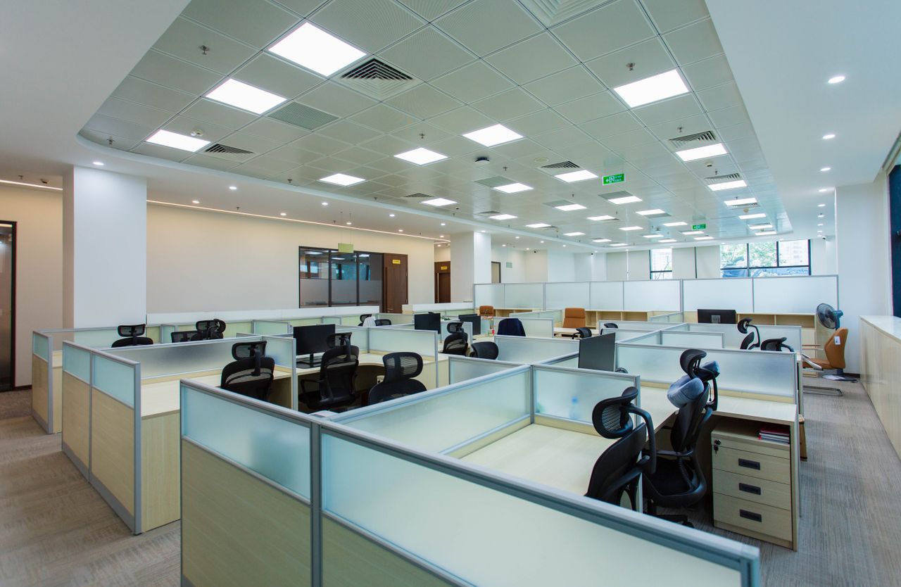 services-04 Spacious open-plan office with cubicles and modern furnishings, ideal for collaborative work environments.